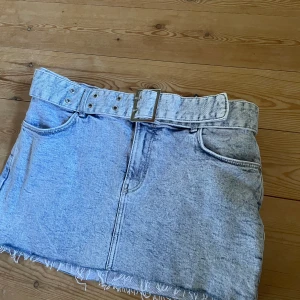 Low waist jeanskjol  - En lågmidjad ljus jeanskjol från BERSHKA i storlek 36. Den är stretchig. Säljer för den är för stor för mig, kan fixa bättre bilder om så önskas