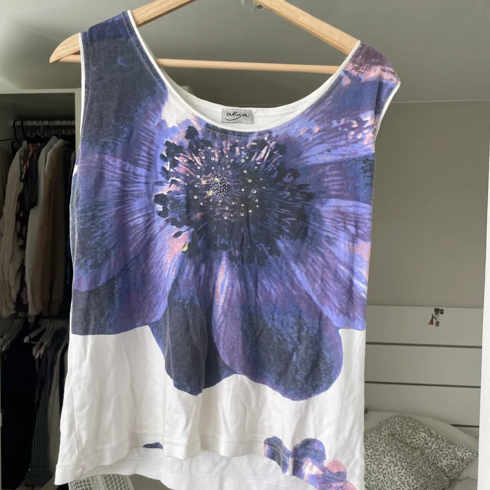 jättefin topp med blommigt motiv och pärlor! köpt secondhand. säljer då den inte kommer till användning. står ingen storlek men sitter som en L🪻. Toppar.