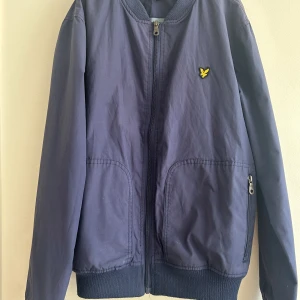 Jacka 14/15 år - Snygg pojkjacka i bra begagnat skick ! Fin mörkblå färg. Lite nopprig i kragen men det syns inte så mycket när den sitter på ! Perfekt jacka kalla sommardagar eller som höstjacka !