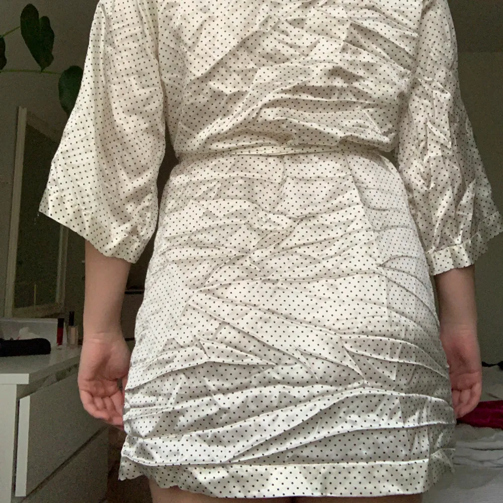 En kort krämvit kimono med svarta prickar. Bra skick. . Övrigt.