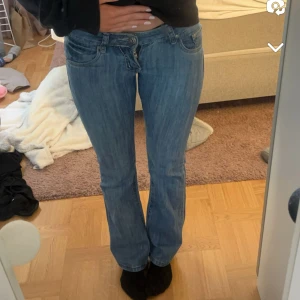 Blåa lågmidjade jeans - Skit snygg lågmidjade unika blåa jeans. Köpte de här på plick men de är tyvärr lite tajta på mig. Midjemåttet är 37cm och innerbenslängden 80cm💕