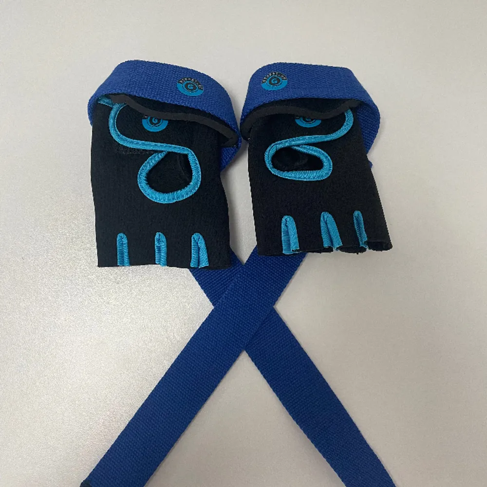 Gymhsndskar i kombination med liftingstrap som kan sättas ihop med kardborre. Produkten hjälper dig att maximera dina lyft och nå dina mål. Den fungerar umärkt till t.ex. marklyft och pullups. Storlek M. Asusteet.
