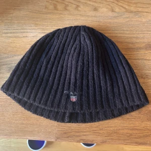 Mörkblå Gant mössa, one size - Ännu en stilren mössa från Gant i ullblandning! I gott skick, passar till det mesta. Kan mötas i Sthlm!