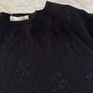 Tröja med svarta stjärnor - Jätteskön tröja med stjärnor gjorda av svarta rhinestones! Superbra skick men kommer inte till användning! Ser tajtare ut p bilden pga tröjan under, passar XS-M beroende på vilken passform man vill ha. Pris kan diskuteras & skriv för fler bilder!💘