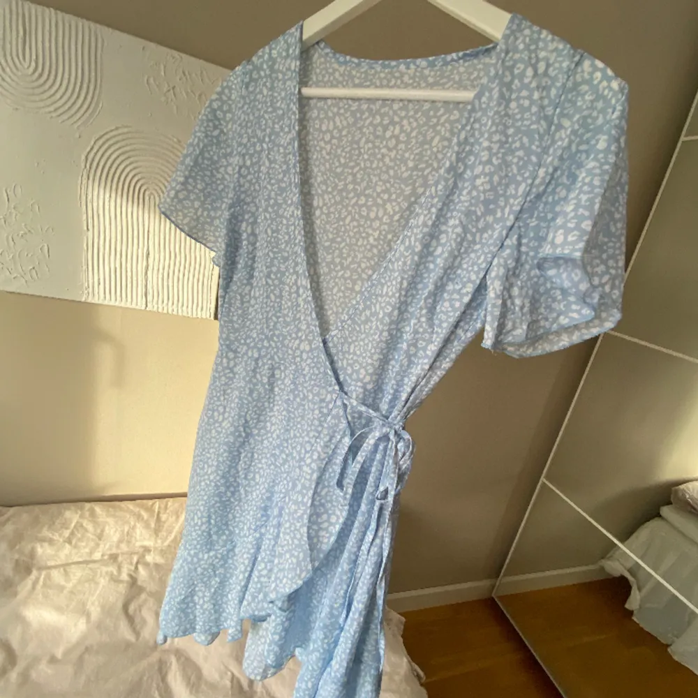 Jättefin somrig klänning i ljusblått med vitt mönster. Knytning i midjan som går att justera. . Klänningar.