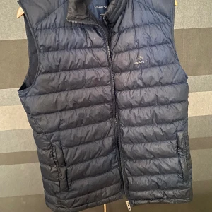 Gant väst - En basic mörk blå väst av Gant. Nypris ligger på ungefär 2100kr.  Säljer för en vättig peng då polaren vill bli av med den.  Finns liten defekt långt nere på västen som knappt syns. Om det finns frågor är det bara skriva!