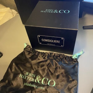 John hatter & CO - Säljer John hatter & co box och dustbag, sälj iväg billigt om det är någon som är i behov av just den här lådan. Min keps hamnade på havets botten så lådan e ganska värdelös för mig nu. 