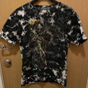 Drainer t-shirt - Ball tshirt med tryck, typ tie-dyed. Dödskallar och krokar och nåt torn med på den också! Stl M.