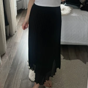 Plisserad kjol - Plisserad svart kjol i en längre modell från nakd!🖤 aldrig använd 