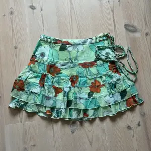 Grön blommig kjol från Wezc med volanger i storlek S. Fint skick. Använd gärna köp nu!