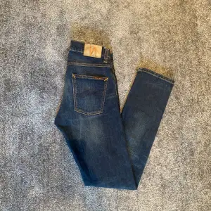 Ett par feta Nudie jeans i modell ”Grim Tim”. Färgen på dessa kallas Dark Dreams. Skick 10/10. De är i storlek 29/32. Nypris 1600kr, mitt pris 499!Skriv vid minsta lilla fundering!😁