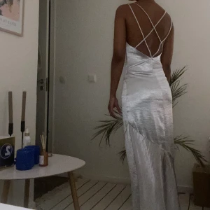 Maxiklänning - Fin silvrig maxi klänning som passar till sittningar, bal eller andra speciella tillfällen. Aldrig använd men köpt på sellpy och inga defekter. Strl xs men passar nog s oxå 