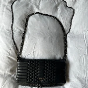Zadig & Voltaire väska - Väska från Zadig & Voltaire. Köpt i butiken i Danmark. Det finns två längder på strapsen dom går även att ta av så att väskan blir till en clutch.  Dustbag, påse, kvitto samt läder lapp med följer. Väskan är i ok skick lite slitningar på nedre sidor.