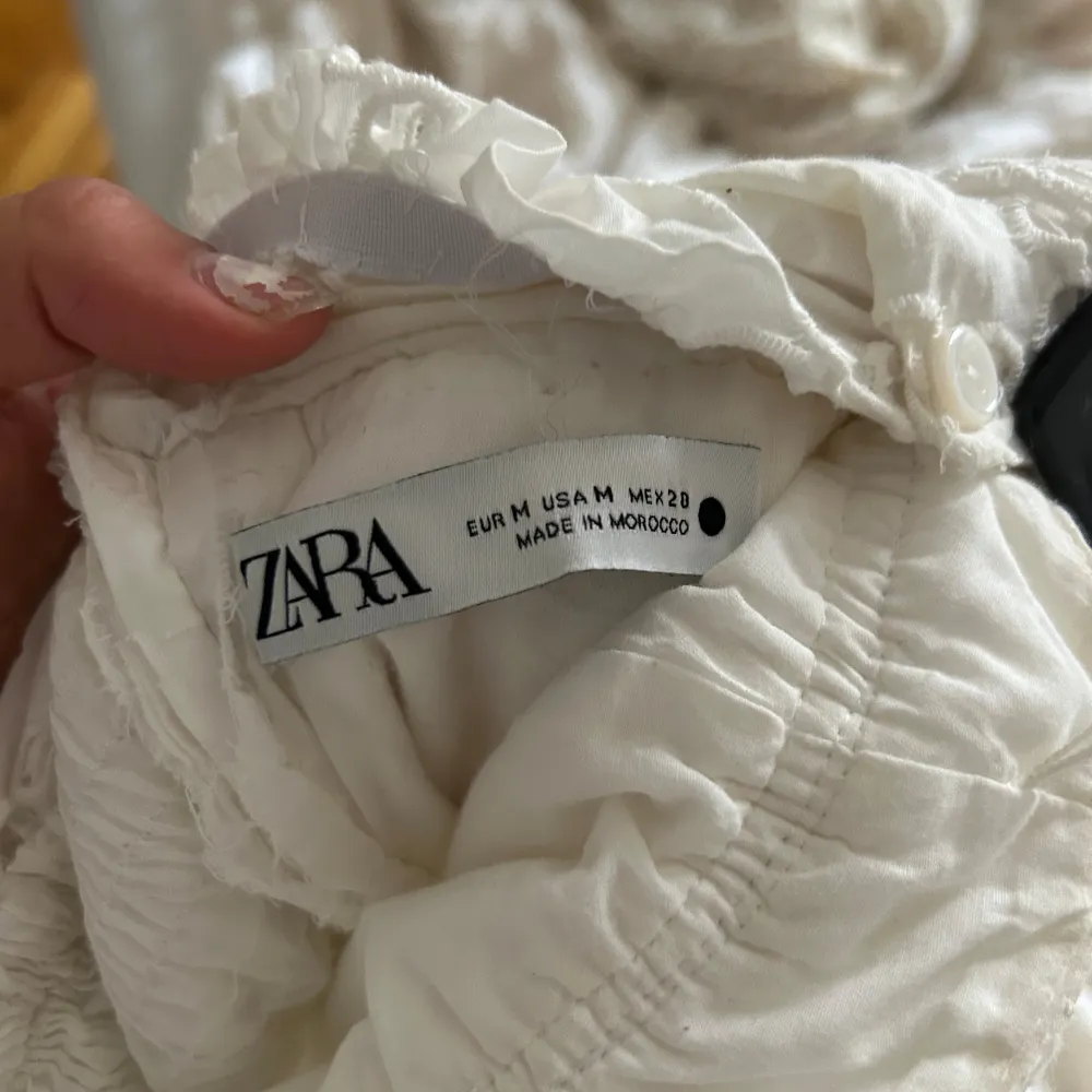 En vit klänning som jag köpte på Zara som mamma sedan sydde om till en snygg klänning utan axlar med sötaste volangerna. Klänningar.