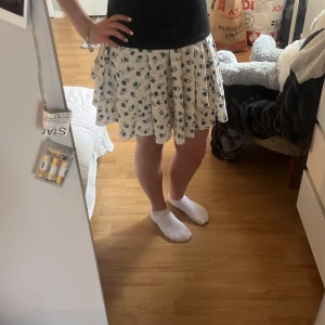 Vit blommig kjol - Säljer den här jättefina blommiga volang kjolen i s från shien, för att de inte kommer till andvändning längre. Andvänd några få gånger.🤍