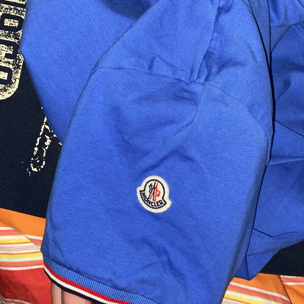 En ljusblå moncler t-shirt i storlek M. Mycket bra skick och enbart använd någon enstaka gång. Köpt på NK i vintras.. T-shirts.