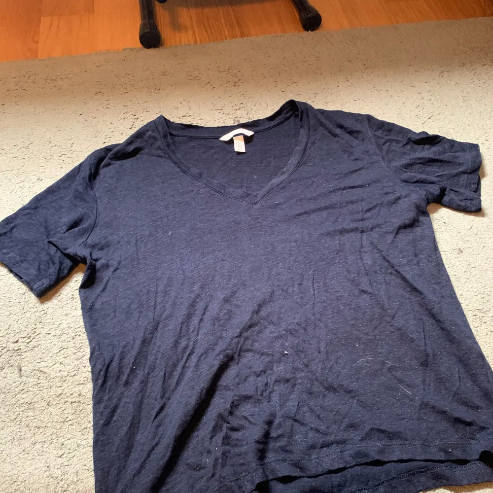 en mörkblå v-ringad t-shirt i skönt material, lite genomskinlig. har lite längre armar än en normal t-shirt, är i storlek M från H&M. T-shirts.