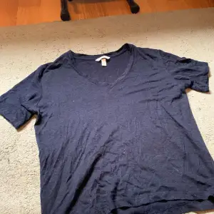en mörkblå v-ringad t-shirt i skönt material, lite genomskinlig. har lite längre armar än en normal t-shirt, är i storlek M från H&M