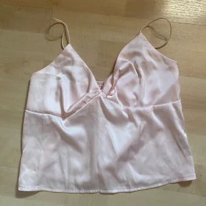 Söt topp  - Säljer denna jättesöta toppen i rosa silkesmaterial som tyvärr va för liten för mig. Helt oanvänd 