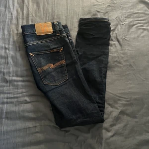 Nudie Jeans - Säljer dessa blå Nudie jeans. De är i riktigt bra skick 9/10 och har lite slitningar på ena benet. Jeansen är i storlek 31/32. Nypris på de ligger på ca 1500 och mitt pris är 499. Det är bara att höra av sig om du har några ytterligare frågor.