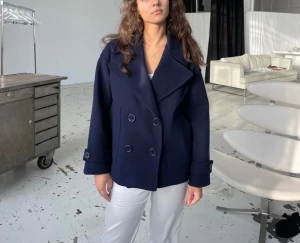 Design by si kappa i färgen Navy - Säljer nu denna ass fina kappan från Design by si. Flitigt använd men väl omhändertagen så inga större defekter förutom att den blivit ytterst lite nopprig(se bild), men inget man tänker på. I övrigt toppen skick! Skriv gärna om ni har fler frågor!🌸