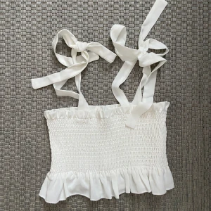 Vit topp med snörning - jättesöt vit topp med snörning i axelbanden 😇 aldrig använd endast provad! 💕pris kan diskuteras 