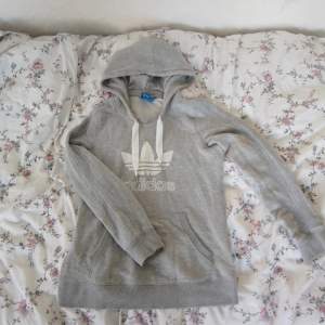 Säljer en grå Adidas hoodie i strl S. Den är använd ca 4 gånger. Den är som helt ny. Den har gråa Adidas sträck på armarna. Säljer den för 100kr! 