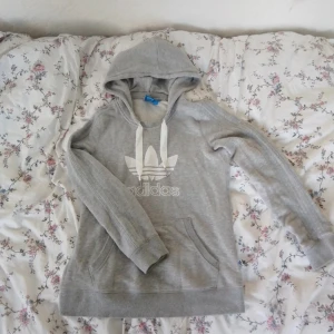 Adidas hoodie - Säljer en grå Adidas hoodie i strl S. Den är använd ca 4 gånger. Den är som helt ny. Den har gråa Adidas sträck på armarna. Säljer den för 100kr! 
