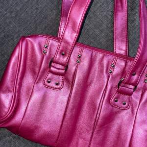 Oanvänd handväska i metallisk rosa (riktiga färgen med blixt på första bilden). Med innerfickor och dragkedja!Köpt second hand 🩷