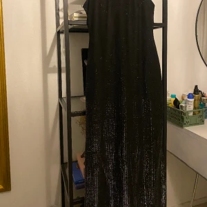 Långklänning - En långklänning som är lite skirmlig/silvrig. Perfekt för fest! Köpt secondhand och använt en gång.