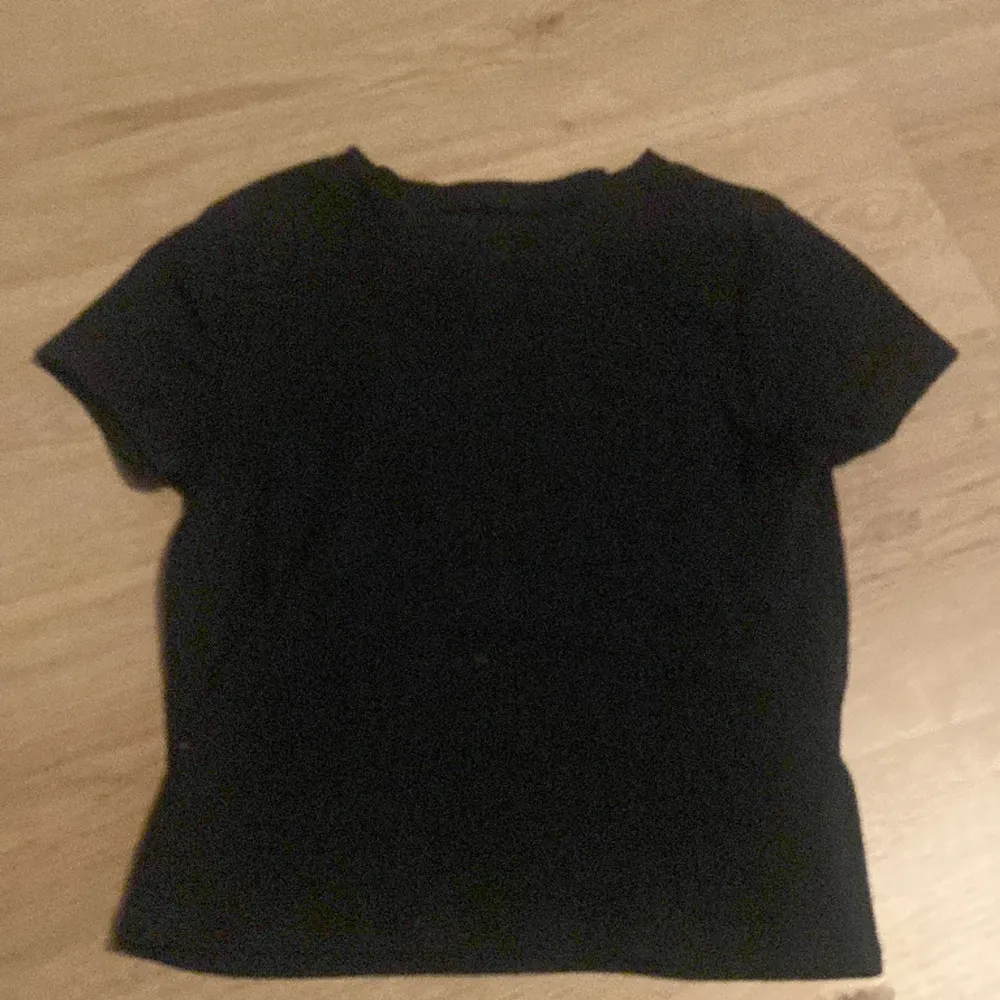 Svart T-shirt från H&M. Använd fåtal gånger, stl 146/152 men passar mig som bär stl XS. Säljer då den inte används. Den är ribbad och lite croppad. T-shirts.