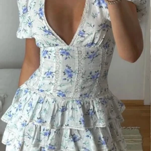 Zara blå blommig klänning - Endast använd en gång. Obs ej äkta, jag blev lurad här på plick men den är sjukt likt orginalet så ingen märker skillnad. Jag är 160 så den är ganska kort. 