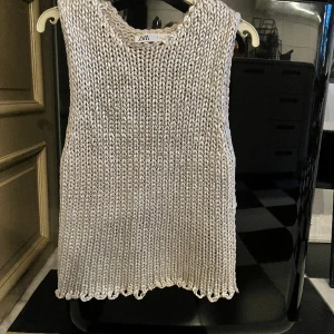 Stickad silvrig topp storlek M - Stickad topp i silver, storlek M. Sålde slut direkt när den fanns i butik. Fint skick inget att anmärka på.