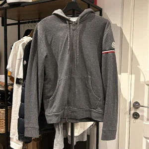 Moncler Zip Up Hoodie - Moncler Zip Up Hoodie i utmärkt skick, endast zippern som är lite trög längst ner, går o stänga och går bra hela vägen upp. Storlek L passar en S/M, nypris 5500 mitt pris 1500. Bara att höra av sig vid frågor eller funderingar, över 50 refs finns!