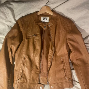 Brun jacka i läderimitation  - Jackan är ganska tunn och perfekt för sommarkvällar eller liknande. Den är i bra skick och jag gör av med den pga att den blivit för liten