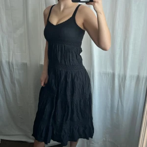 Svart klänning - Svart långklänning med volang och spets från Lindex 💓 Har en dragkedja på sidan 