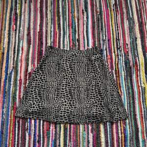 Kjol med leopard-liknande mönster, minikjol. Knappt använd!  Midjemått rakt över ca 33 cm  Längd ca 44 cm