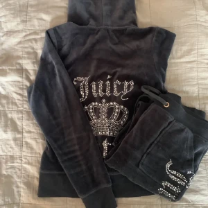 Juicy Couture - Juciy set i mörkt gråt, knappt andvänt. Inga håll alla paljetter sitter kavar. Säljer både byxor och tröjan för 400kr. Säljer då de inte kommer till användning.Kan mötas up i Stockholm 