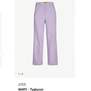 Högmidjade lila kostymbyxor från JJXX. Modellen heter JXMary Regular HW Pant Noos, färg Violet Tulle. Strl W28/L32.  Nya och endast provade på en gång. Kolla andra bilden för exakt färg.