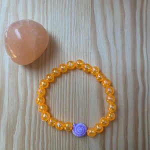 Armband -  Egengjort armband, oranget🧡 och lila 💜 snäcka🐚. Knutsen syns 🫣inte. Lite lite för litet för mig men aldrig använt. 10kr 💵 frakt. Ha en fortsatt bra dag!!!!❤️❤️❤️❤️❤️❤️❤️❤️❤️❤️❤️ 