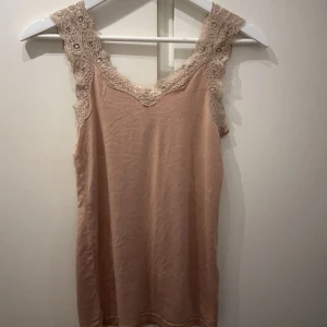 Gulligt linne - Gulligt gammelrosa linne med brädan axelband i spets från Vero Moda. Använt men i fint skick! Storlek S. 🩷 Köparen står för frakt!!