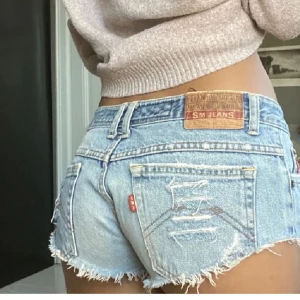 Lågmidjade jeansshorts  - Jättesnygga lågmidjade jeansshorts med slitningar. Skriv för mått och fler bilder😊köparen står för frakten, men kan även mötas upp💗