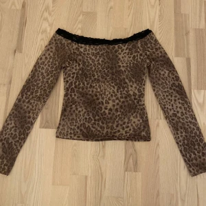 Leopard tröja - Sjukt fin och festlig leopard off-shoulder tröja med spets. Den är i bra skick men kommer tyvärr inte till användning längre. Kontakta mig gärna vid frågor osv.💗