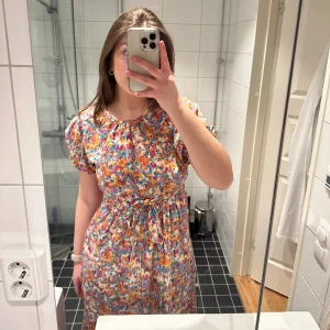 Lång blommig klänning - Säljer denna helt nya och oanvända klänning