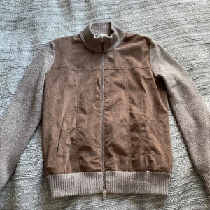 Zip up i mocka och ull  - Zip up tröja inköpt i Madrid förra året från Mirto för ungefär 3000 svenska kronor. 100% ull och ett lager av brun mocka. Väldigt stilren och passar till det mesta. Sitter som en medium. 
