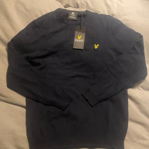 Lyle & scott tröja - Jättefin mörkblå stickad tröja från lyle & scott! Den är helt ny med lappar kvar i storlek M! 