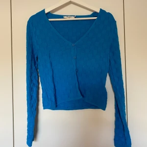 Blå tröja - Blå tröja i storlek S från NAKD. Knappar framtill & något croppad modell