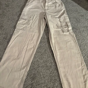 Cargo jeans från H&M  - Beiga cargo jeans från H&M oanvända.