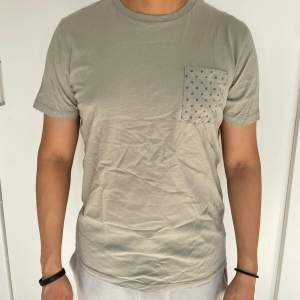 Ljusgrön herr T-shirt från Jack & Jones i stl M. Bredd axel till axel: 42 cm. Längd: 62 cm. Material: 100% bomull. Superfint skick.