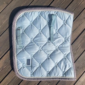 Equestrian stockholm schabrak Ice blue - Equestrian stockholm schabrak i färgen Ice blue. Storlek cob, dressyr. Nytvättat. Nypris: 899 kr. Pyttelite gult på ena sidan vid loggan (se sista bilden) men inget som märks tydligt.